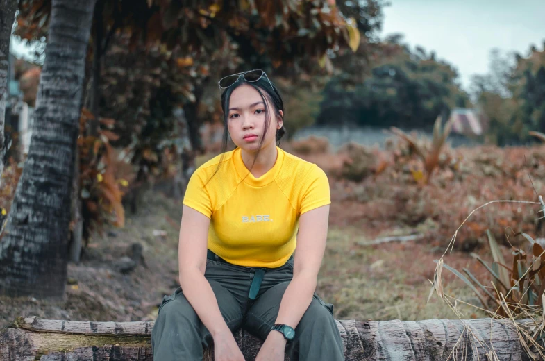 a woman is sitting on a bench outside