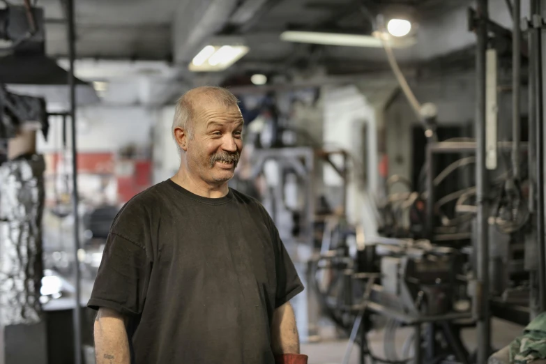 a man in a shirt with a mustache in an industrial area