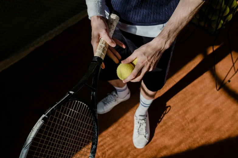a man is sitting with a tennis racket and ball in hand