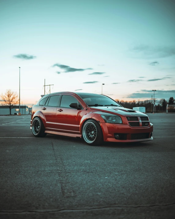 a red car sits in an empty parking lot