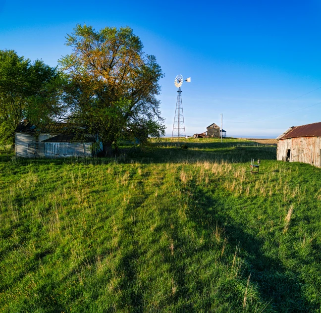a brick barn is sitting on a grassy field