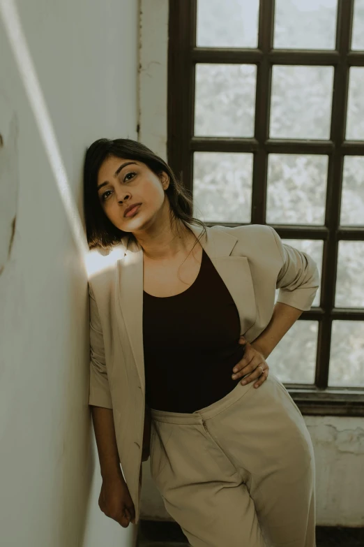 a woman leaning up against a wall in an alley way