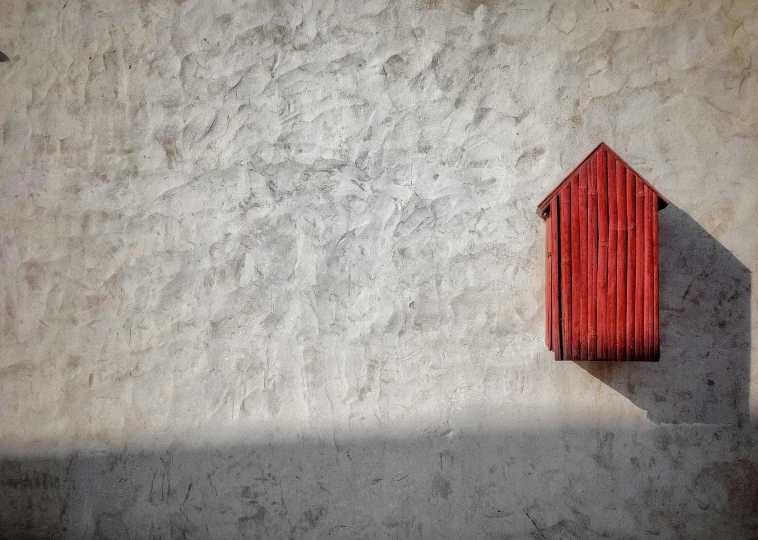 a red object casts a shadow over the cement surface