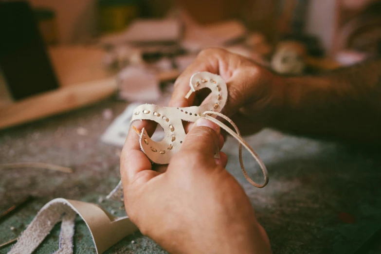 an open pair of hands holding a ribbon with the string wrapped around it