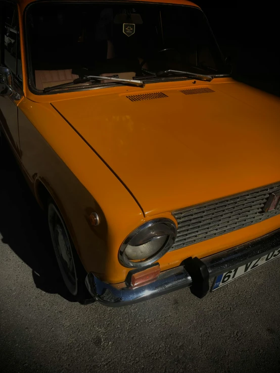 a yellow car parked in a dark parking lot