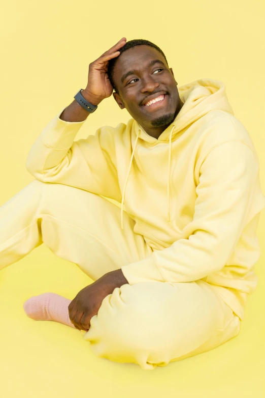 a black man posing for the camera on a yellow background