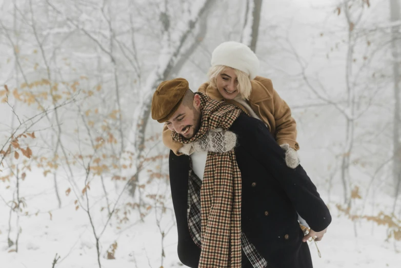 young couple in cold forest taking picture with cellphone