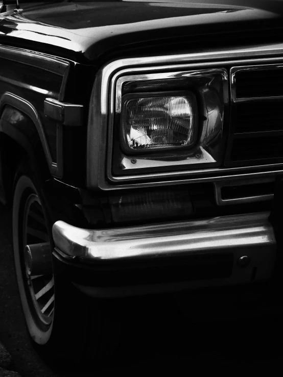 black and white pograph of a pickup truck's headlights