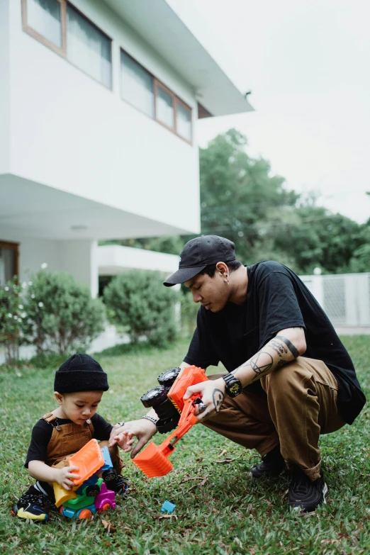 father and son playing with toy in backyard