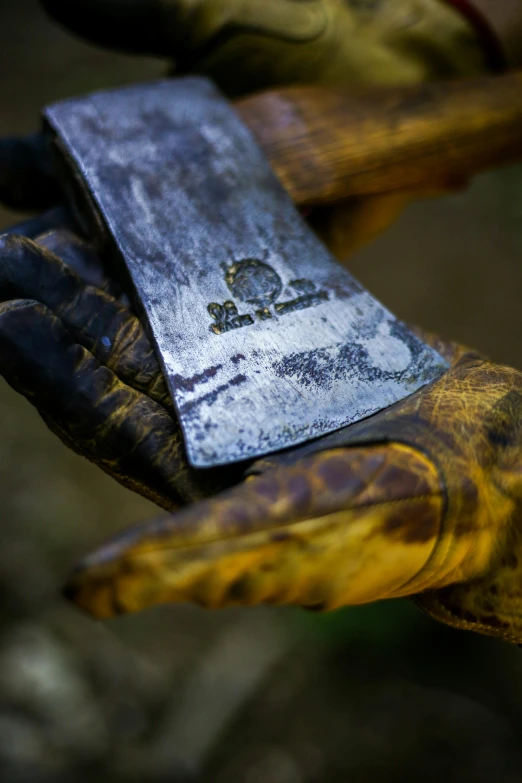 a gloved hand holds a small metal tag