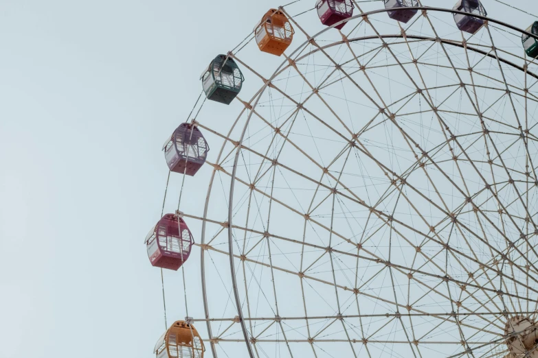 a ferris wheel has several caged cages on each of it