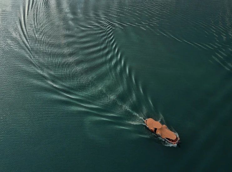 a small boat in the water with its oars moving