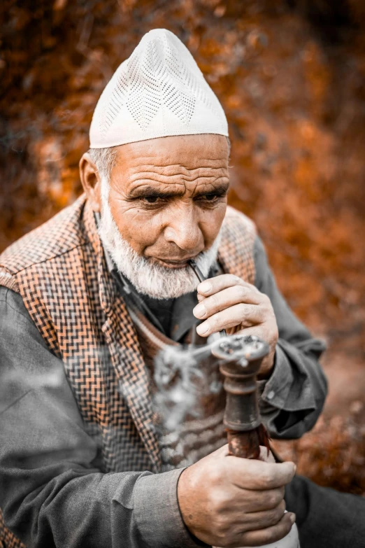 an old man holding a pipe in his hands