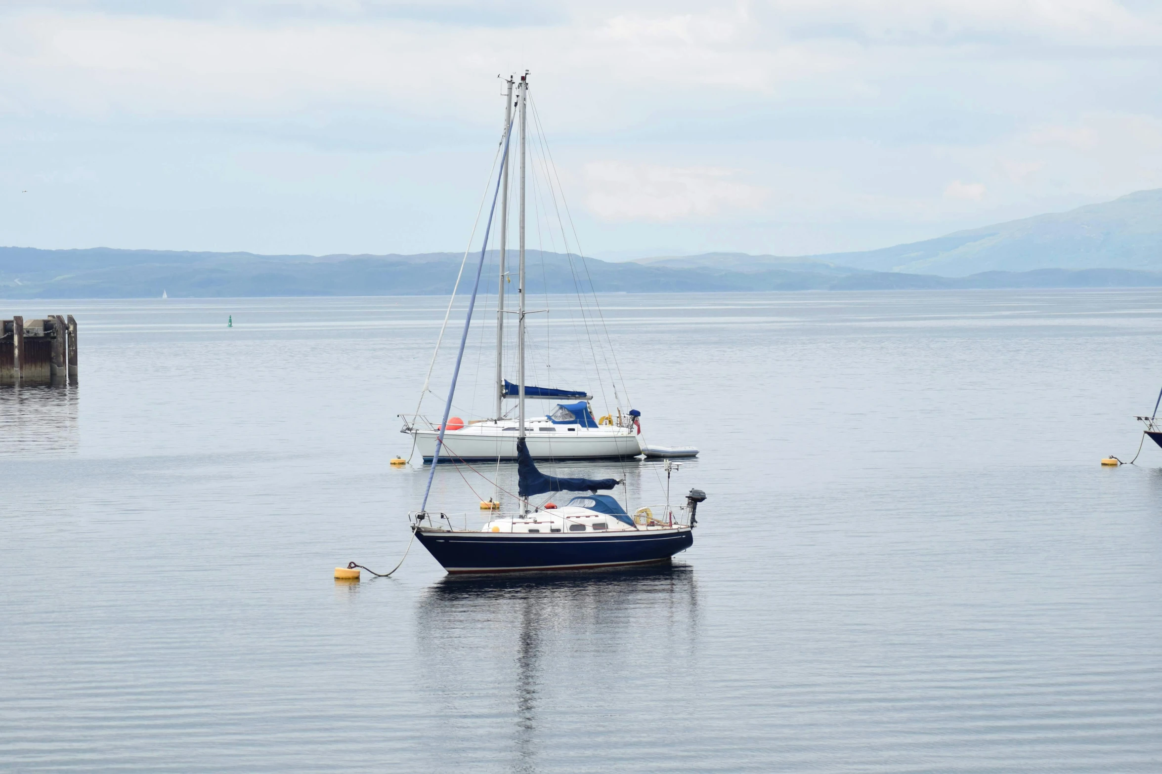 boats are in the water with mountains in the distance