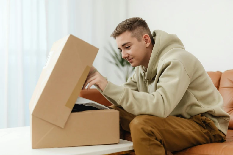 the man is sitting on the couch with some boxes