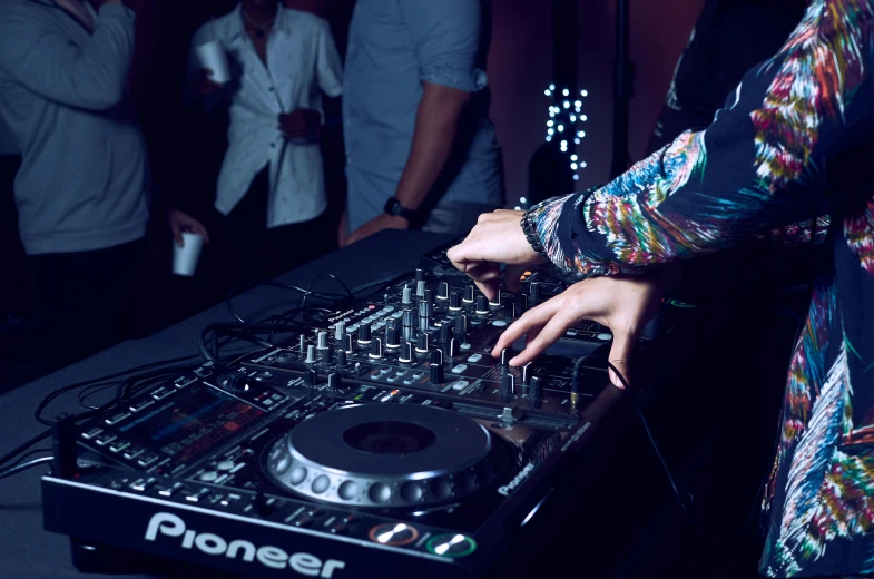 a dj spins his turntable while people dance