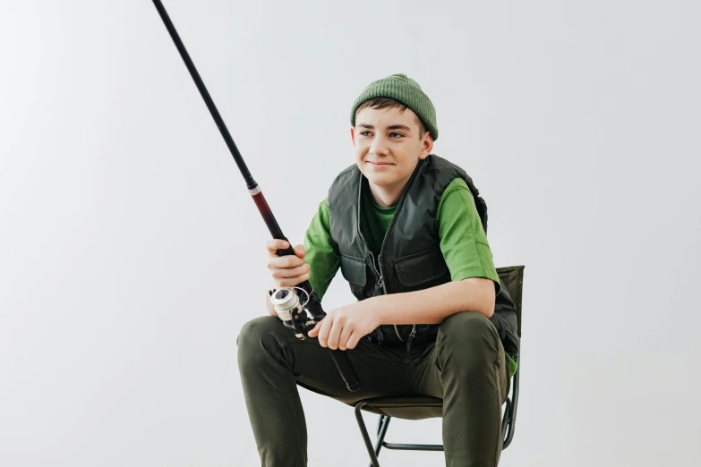 a man sitting in a chair holding a fishing pole