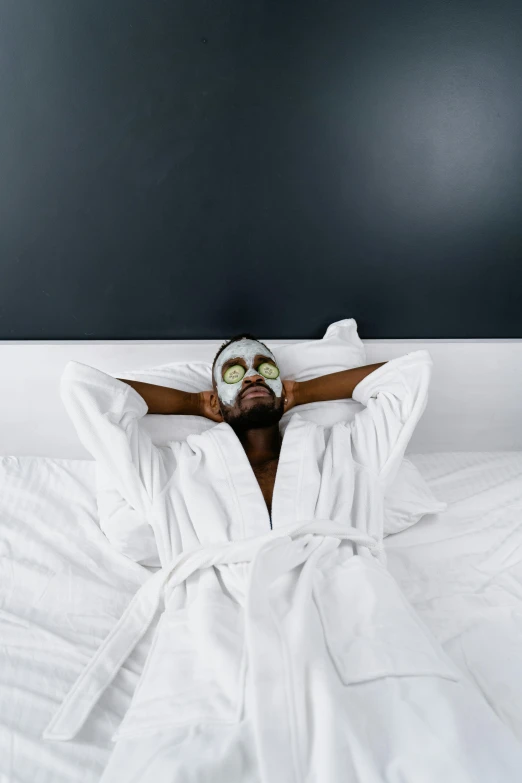 a person laying in bed with white sheets on their sides