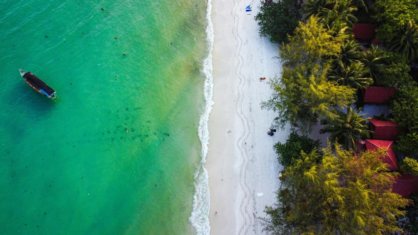 a boat sailing on the ocean next to a beach