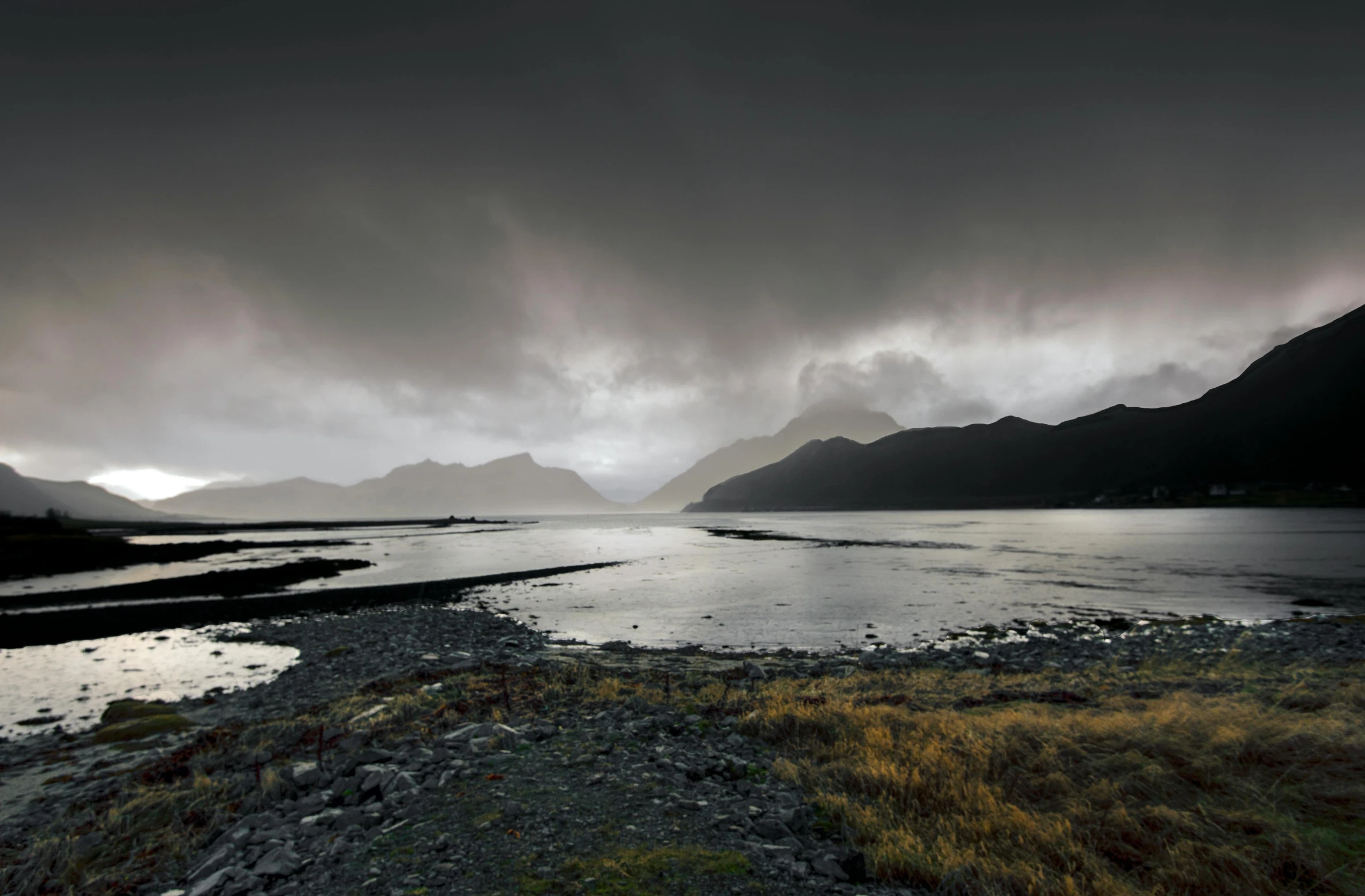 a wide view of a lake with mountains in the background