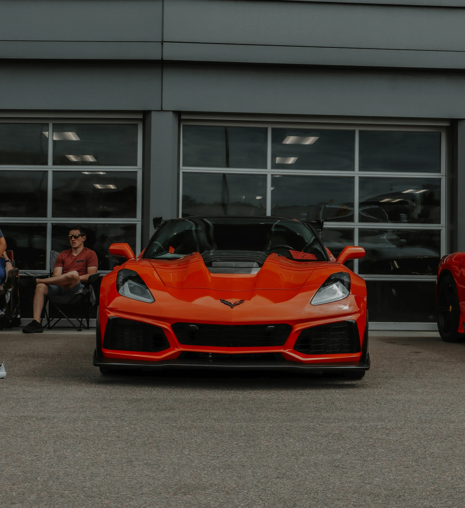 two red sports cars are parked next to a building