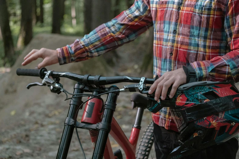 the man holds his bicycle in the woods