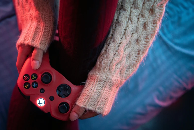 a close up of a person wearing red and black video game controller controllers