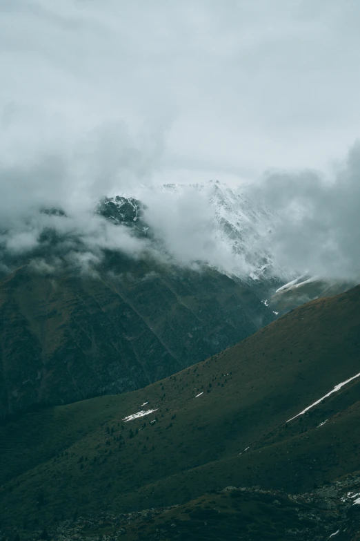 mountains covered in snow and clouds in the mountains