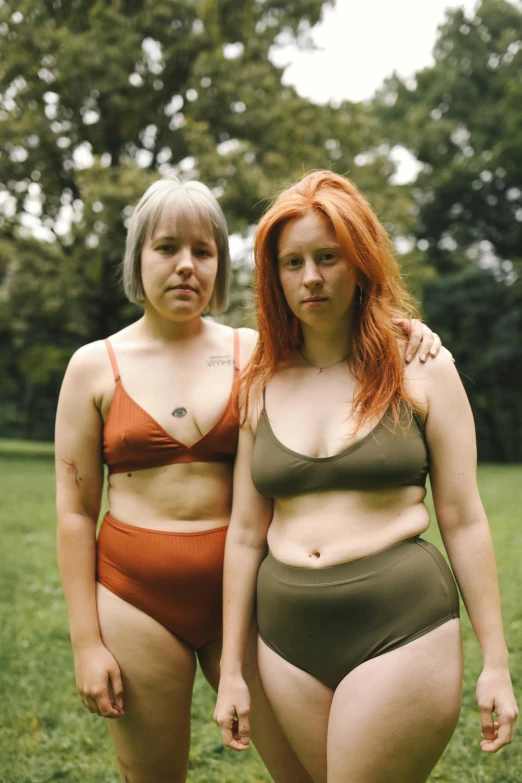 two woman standing next to each other in a field