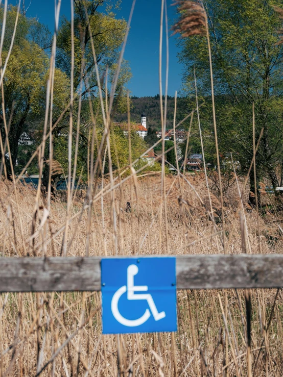 the blue sign is near a wooden fence