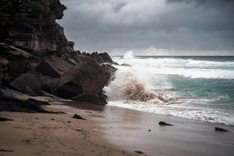 a large wave crashing into the rocks of a cliff