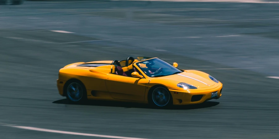 a car driving down the track while people look at it