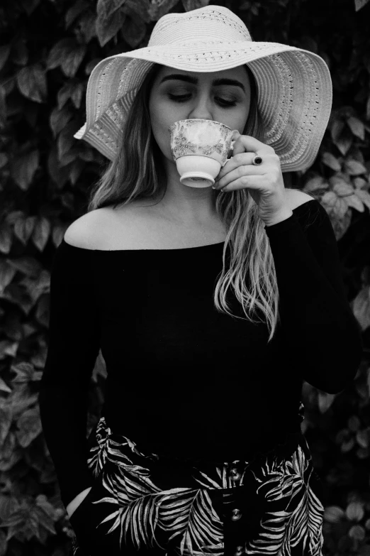 black and white pograph of a young woman wearing a wide brimmed hat