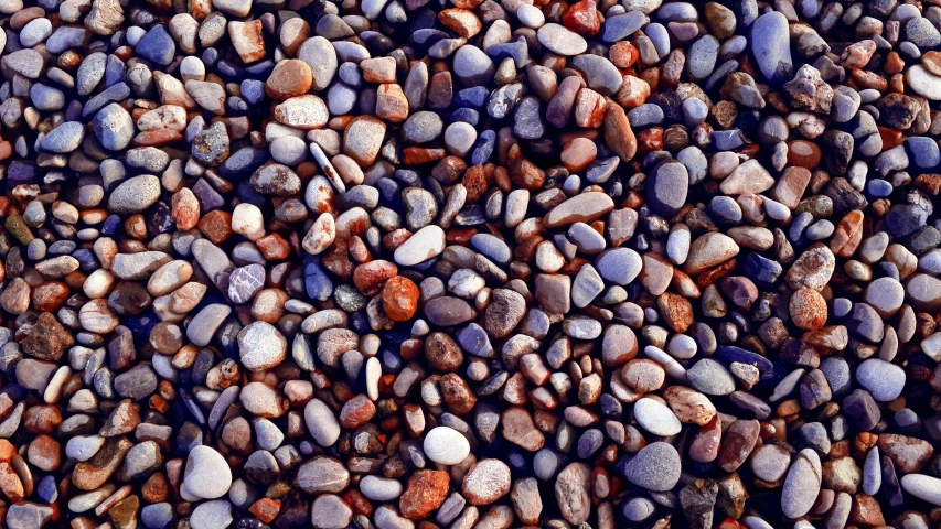 rock wall in front of the road with several small stones on it