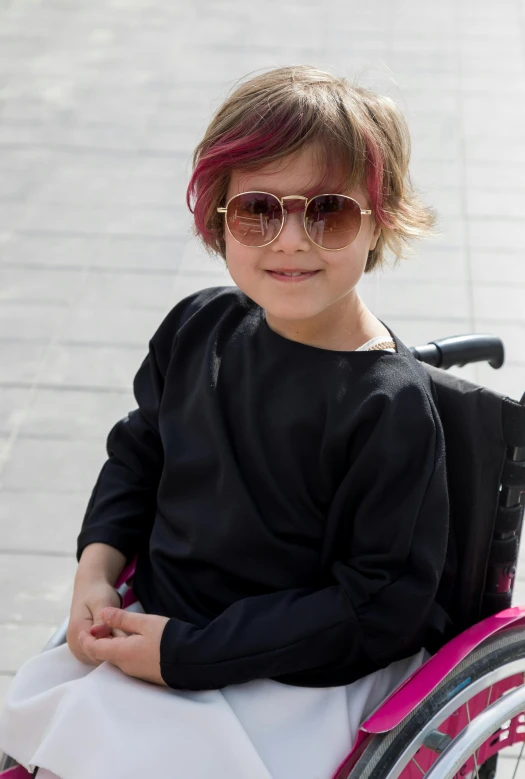 a  with pink hair and sunglasses in a wheelchair