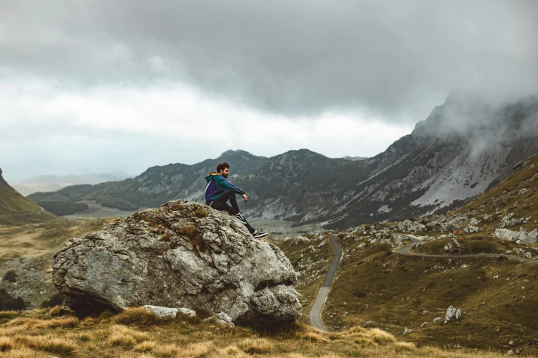 a man is sitting on top of a mountain