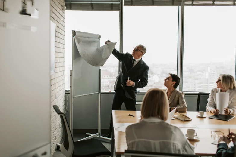 a man in suit standing next to a white board