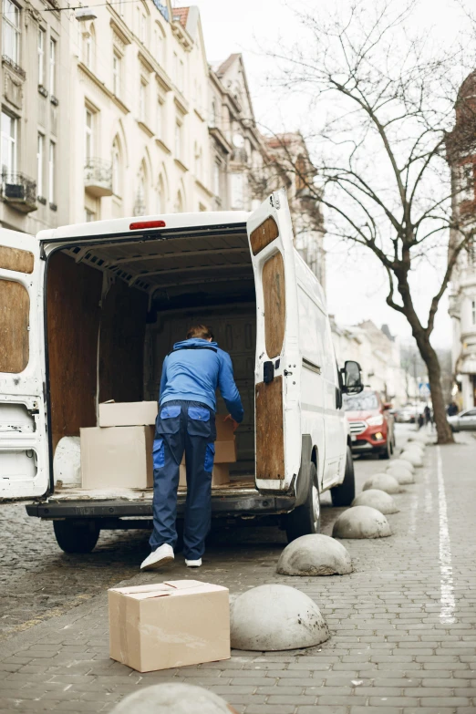 a man loading boxes into an open white van
