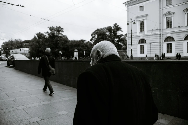 a man wearing a headscarf and walking on the sidewalk