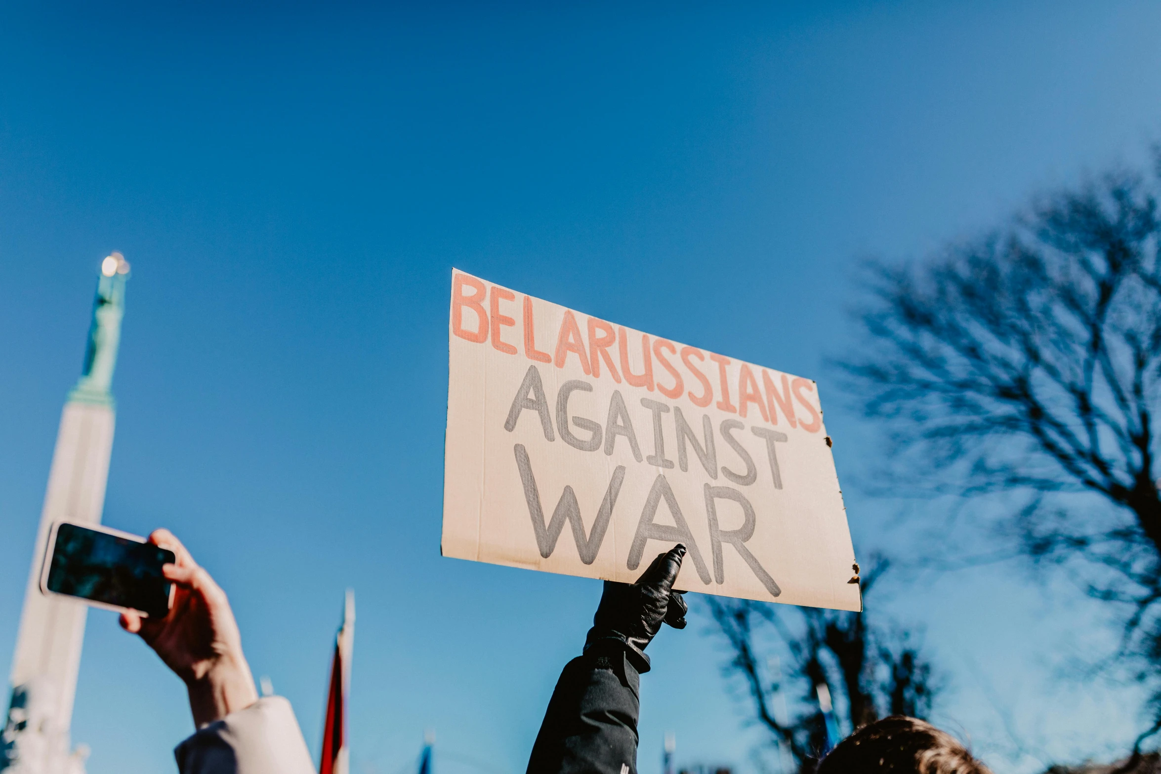 someone holding up a sign reading the slogan, against war