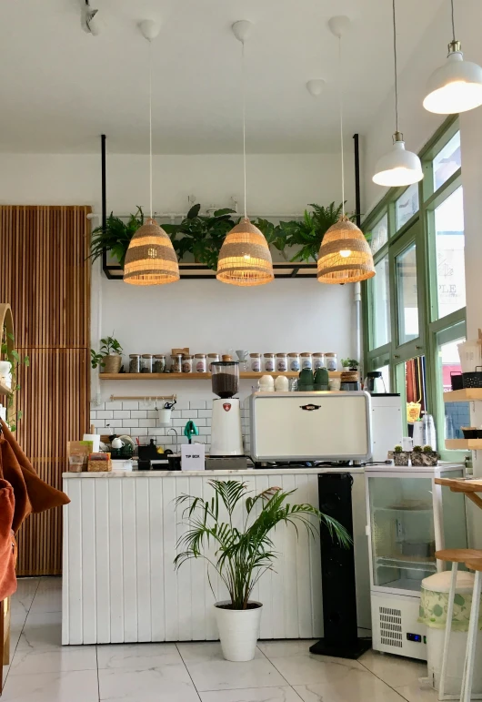 a kitchen filled with lots of furniture and hanging lights