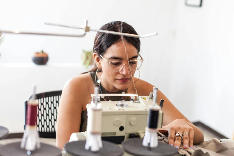 a woman sitting at a table with sewing machine