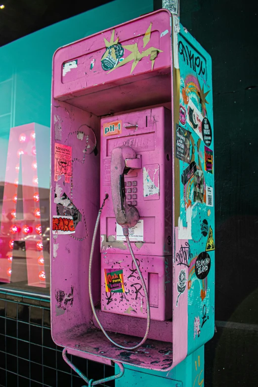an old, neon pink phone is decorated with stickers