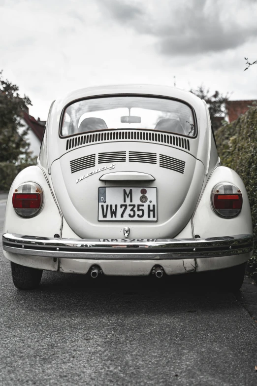 a white volkswagen bug is parked on the street