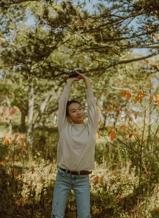 young woman stretching her arms in the woods