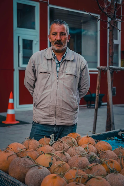 a man stands by some fruit that is being harvested