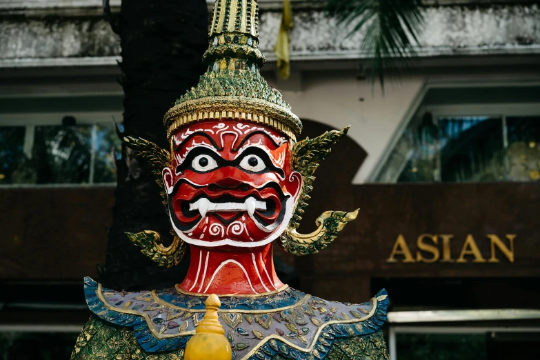 the statue is painted red and green with a large smile