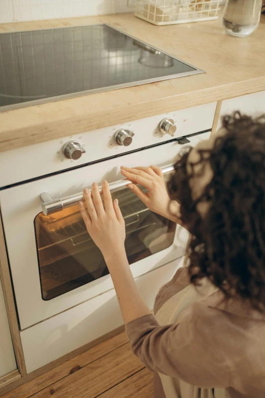 a woman is taking soing out of an oven