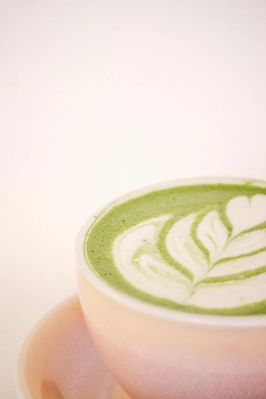 a cup with a green swirl and white design in it