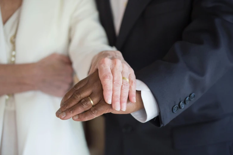 a close up of two people holding hands